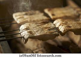 Skewered fish slices on barbeque