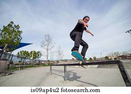 Young man skateboarding on top of railing