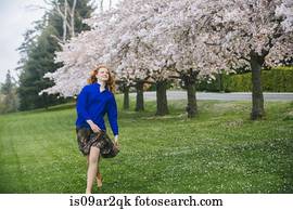 Young woman dancing barefoot in spring park