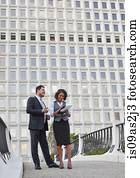 Business people standing talking holding paperwork