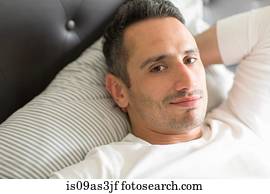 Mid adult man relaxing on bed