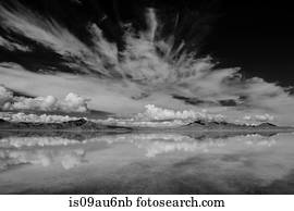Reflection pool of horizon over water, mountain range and clouds, black and white, Bonneville, Utah, USA