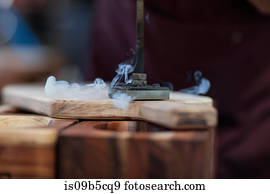 Close up of branding iron burning imprint onto chopping board in factory