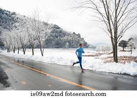 Mature male runner running on road in winter, Lake Kawaguchiko, Mount Fuji, Japan