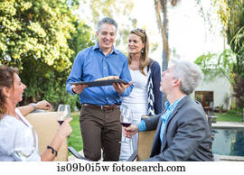 Mature man serving fish cuisine at garden party