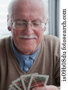 Senior man playing cards at home