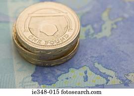 Pound coins on euro note