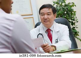 A doctor handing a patient a prescription