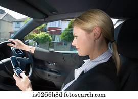 A woman using a cell phone in the car