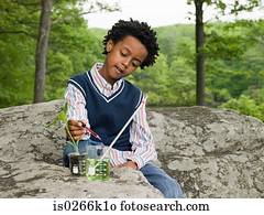 A boy doing an experiment on a plant