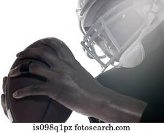 An american football player holding a football