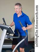 Mature man exercising on a cross trainer