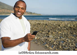 Man using a cellular telephone on a beach
