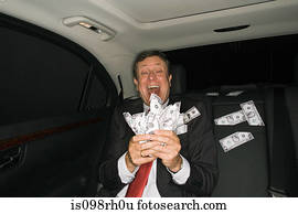 Businessman counting money in a car