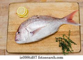 Fish on wooden chopping board