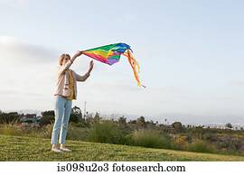 Young woman in a field with a kite