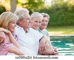 Mature friends by swimming pool