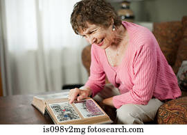 Senior woman looking at family album Senior woman looking at family album
