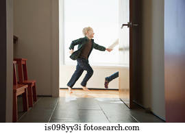 Two children running past doorway