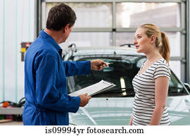 Mechanic discussing car with young woman