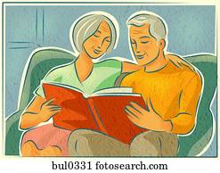 An elderly couple looking through a photo album together An elderly couple looking through a photo album together