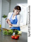 Young woman seasoning a salad