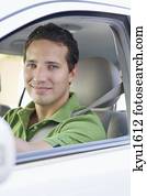 Portrait of a smiling mid adult man driving a car