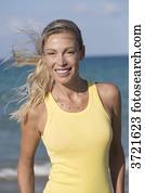 Portrait of smiling blond woman with yellow tank top