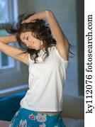 Young smiling woman in white tank top dancing