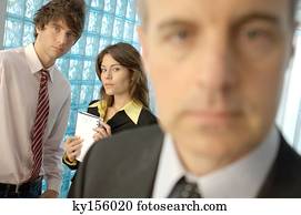 Businessman in office with colleagues in background