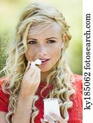 retrato, de, mulher jovem, comer, um, iogurte