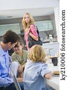 Woman standing beside her family having breakfast