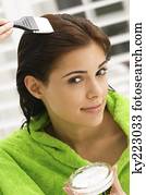 Portrait of a woman applying hair color in her hair