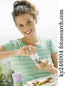 Woman seasoning salad