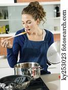 Woman tasting food in the kitchen
