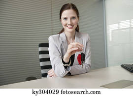 Female financial advisor holding a car key in an office