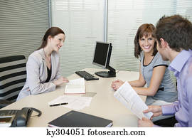 Female real estate agent and a couple discussing in an office
