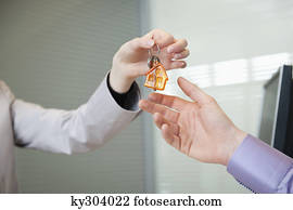 Female real estate agent giving house keys to a man