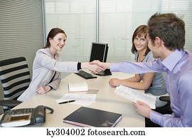 Female real estate agent shaking hands with a couple