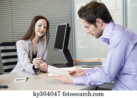 Female real estate agent showing a brochure to a man