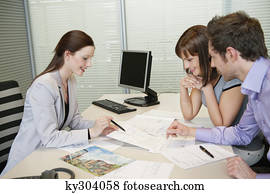 Female real estate agent showing a brochure to a couple