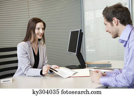 Female real estate agent showing a brochure to a man