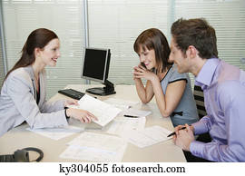 Female real estate agent showing a brochure to a couple