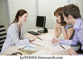 Female real estate agent showing a brochure to a couple