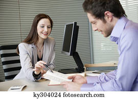 Female real estate agent showing a brochure to a man