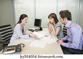 Female real estate agent showing a brochure to a couple