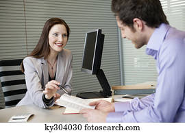 Female real estate agent showing a brochure to a man