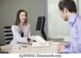 Female real estate agent showing a brochure to a man