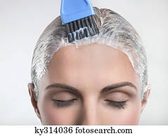 Young woman applying hair color