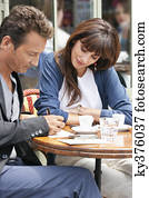 Woman looking at a man signing bill in a restaurant, Paris, Ile-de-France, France